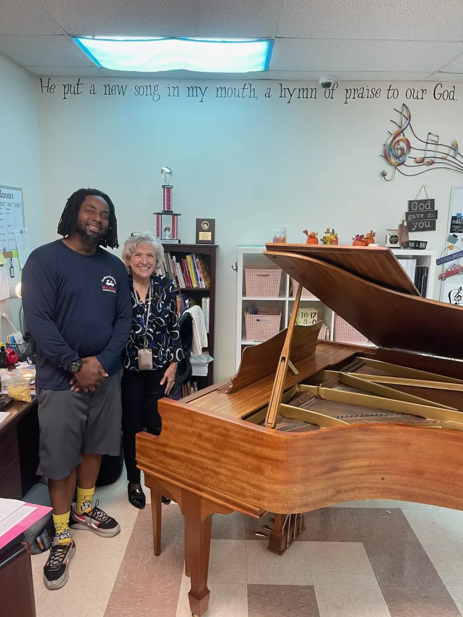 M.C. Movers crew member with a customer and the grand piano he moved