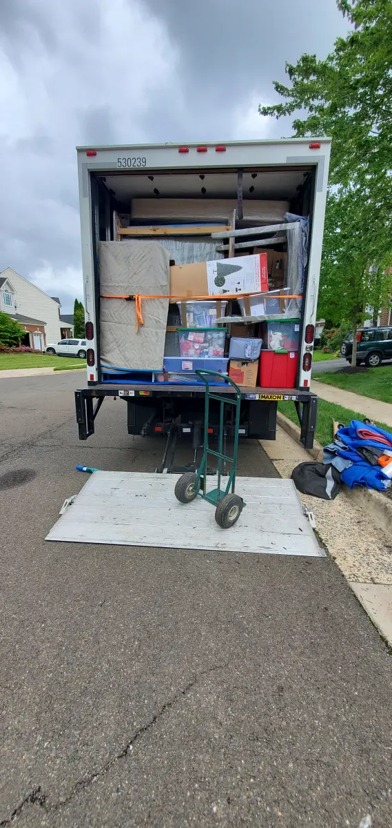 Moving truck fully loaded and strapped by the M.C. Movers crew on a residential street